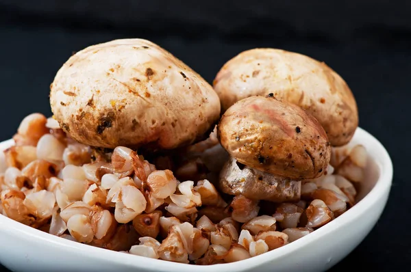 Гречка и грибы на белой тарелке, здоровая еда . — стоковое фото