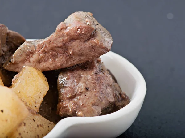 Gestoofde kippenlever met appeltjes op een witte plaat, voeding, dieet voeding. — Stockfoto