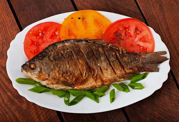 Pieczona ryba karp na białym talerzu z pomidorami — Zdjęcie stockowe
