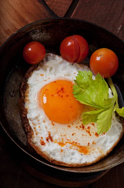 Підсмажене яйце на сковороді, посипане гострим перцем . — стокове фото