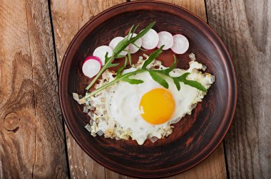 Roka ve turp ile dekore edilmiş soğan, kızarmış yumurta.