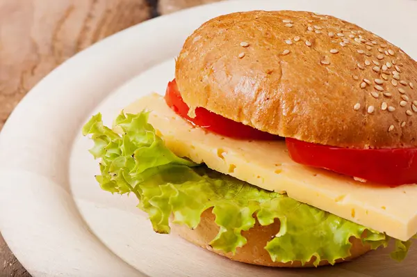 Broodje met kaas, salade en tomaat. — Stockfoto