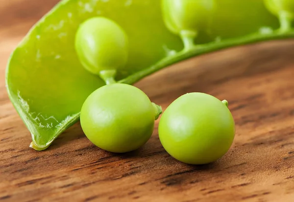 Zoete groene erwten op een oude houten achtergrond. — Stockfoto