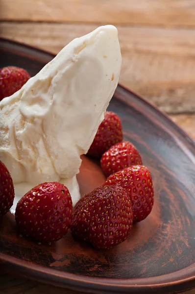 Eis mit Erdbeeren auf altem Holzgrund. — Stockfoto