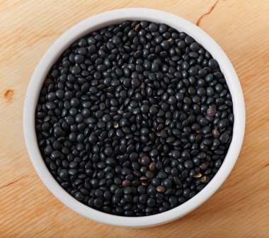 Mercimek tohum eski bir ahşap zemin üzerine beyaz bir plaka üzerinde.