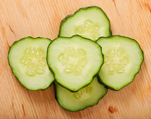 Pepino en rodajas sobre un fondo de madera, vista superior . — Foto de Stock