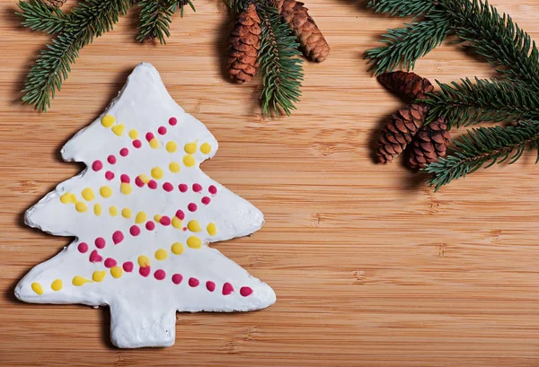 Samenstelling van de New Year's koekjes en Spar takken op een houten ondergrond, Kerstmis achtergrond. Kerstkoekjes. — Stockfoto