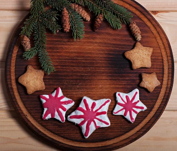 Samenstelling van de New Year's koekjes en Spar takken op een houten ondergrond, Kerstmis achtergrond. Kerstkoekjes. — Stockfoto