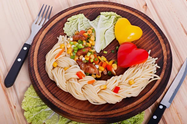 Pasta with vegetables and turkey meat, decorated with heart from vegetables diet menu. Valentine\'s Day.