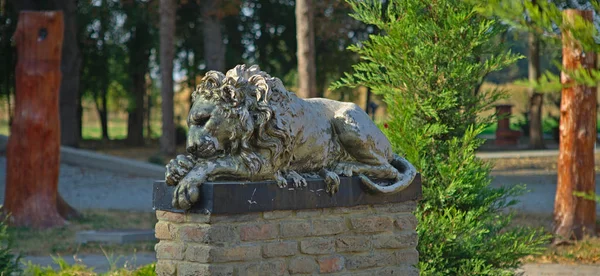 Bronzová socha lva na cihlovém podstavci — Stock fotografie