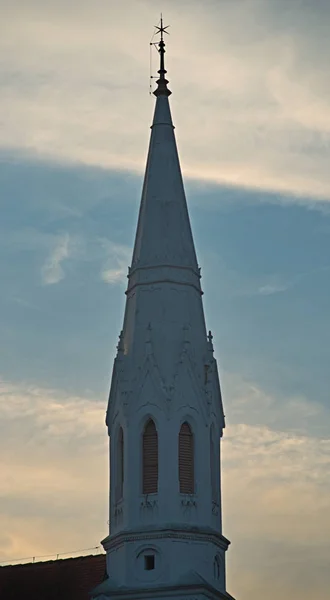 Alter weißer Glockenturm einer protestantischen Kirche vor bewölktem Himmel — Stockfoto