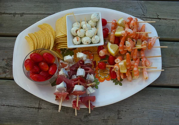 Varios alimentos preparados para el aperitivo en el plato en la mesa de madera — Foto de Stock