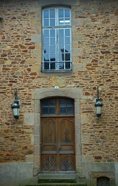 Wooden entrance door and window above on old stone house — Stok fotoğraf