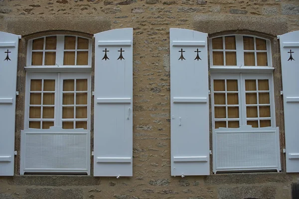 Duas janelas com persianas de estilo antigo na parede de pedra — Fotografia de Stock