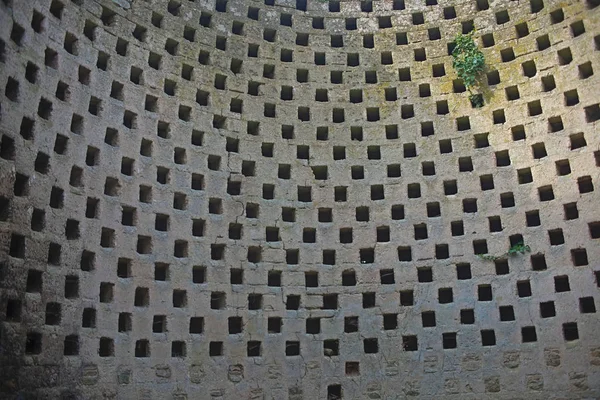 Round stone wall with many holes on an even distance — Stock Photo, Image