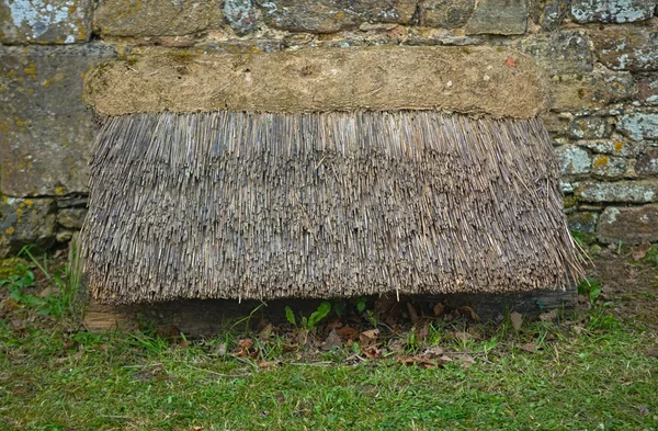 Canopy de cana de estilo antigo ao lado de uma parede de pedra — Fotografia de Stock