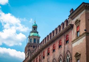 Bologna 'daki Piazza Maggiore eski salon kulesi. Arkasında büyük bir saat ve mavi gökyüzü var. İtalya