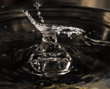 Su damlası su sürahisi şeklinde sıçrar. Yakın plan.