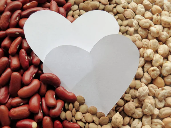 Närbild av vit hjärta form på Raw röda bönor, linser och chick — Stockfoto