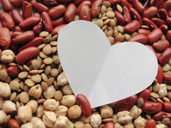 Närbild av vit hjärta form på Raw röda bönor, linser och chick — Stockfoto