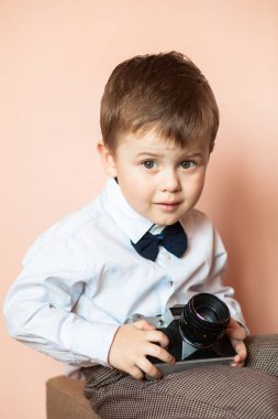 Küçük çocuk yaşlı retro kamera ile. Çocuk eski bir kamera ile