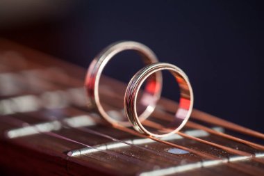 Gitar tellerinde iki nikah yüzüğü. Alanın Sığ Derinliği