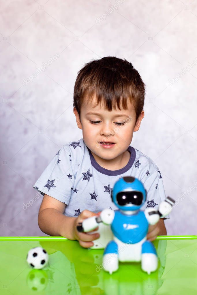 Little boy is playing with robot. Robot for children. Smart toy