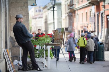 Lviv, Ukrayna - Nisan 2016: Sanatçı Lviv şehir merkezinde bir şehir manzarası çiziyor. Ortaçağ pazarında resim yapan adam.