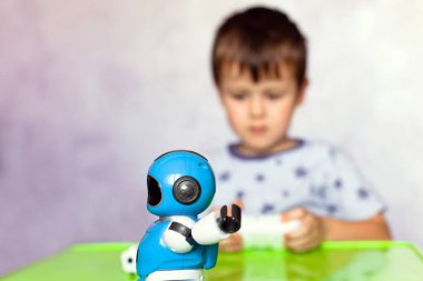 Küçük çocuk robotla oynuyor. Çocuklar için robot. Akıllı oyuncak. Oyuncak robota odaklan