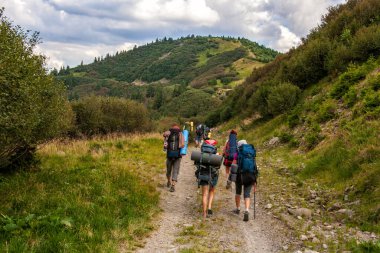 Dağ yolunda bir grup turist. Seyahat, macera ya da dağlara yolculuk kavramı. Arkadan bak.