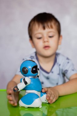 Küçük çocuk robotla oynuyor. Çocuklar için robot. Çocuklar ve oyuncaklar. Oyuncak robota odaklan