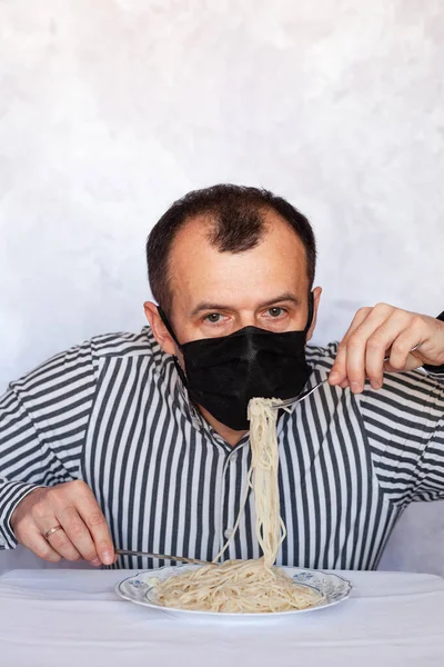 Handsome Man Black Medical Mask Eats Pasta Table Light Background — Stock Photo, Image