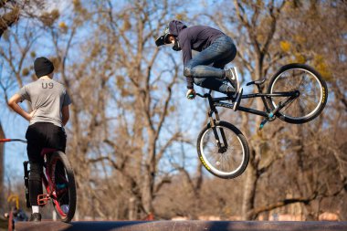 Lviv, Ukrayna - 12 Mart 2020: Genç adam Bmx motoruyla numaralar yapıyor. Gençler bisiklet ve kaykay parkında bisiklet sürüyorlar.