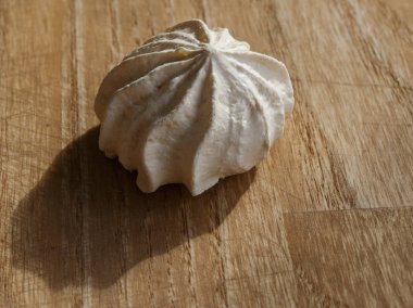 Ahşap masa üzerinde beyaz büyük meringues