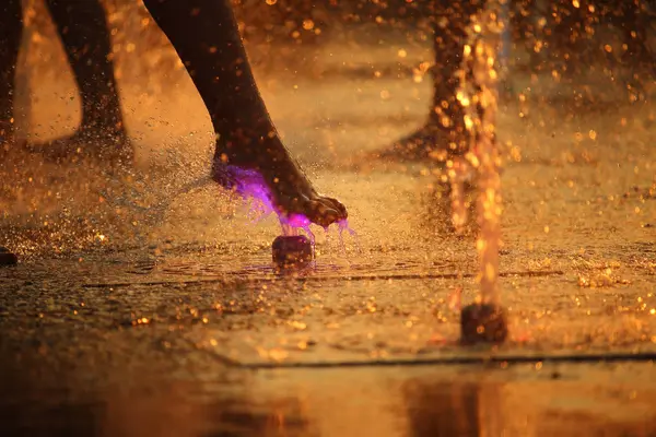 Meninas estão jogando na fonte de luz em um dia quente de verão — Fotografia de Stock