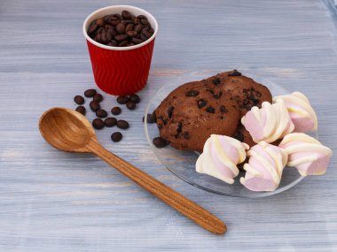 Mavi arka plan üzerinde marshmallows sopalarla çikolata kurabiye