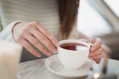 Eller masanın üzerine beyaz fincan tutun