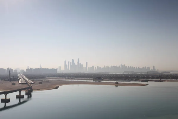 Yüksek bir noktada bir palmiye ağacı, bir Monoray ve bir şehir şeklinde Dubai'deki gökdelenler ile sahilde — Stok fotoğraf