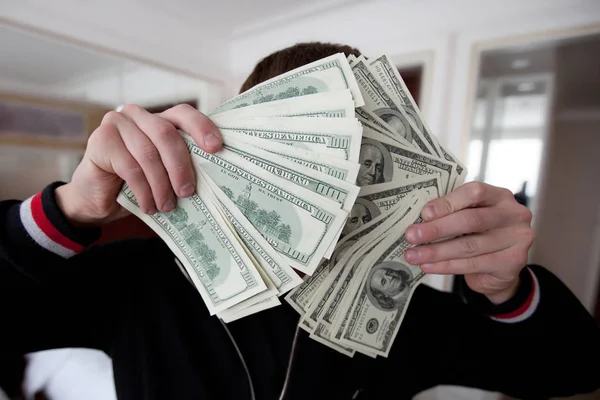 Ein reicher Kerl hält eine Menge Dollars vor der Kamera lizenzfreie Stockfotos