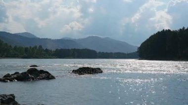 Dağlar ve bulutlu gökyüzü arka plan karşı geniş bir nehir. Hızlandırılmış.