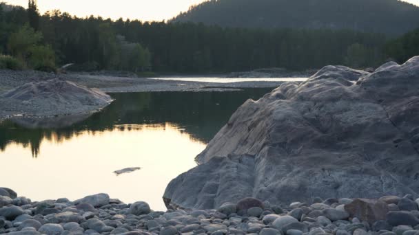 Un lago en medio de grandes rocas en las montañas — Vídeos de Stock