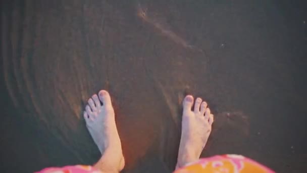 Voeten op het zand staan en worden gewassen door de golven — Stockvideo