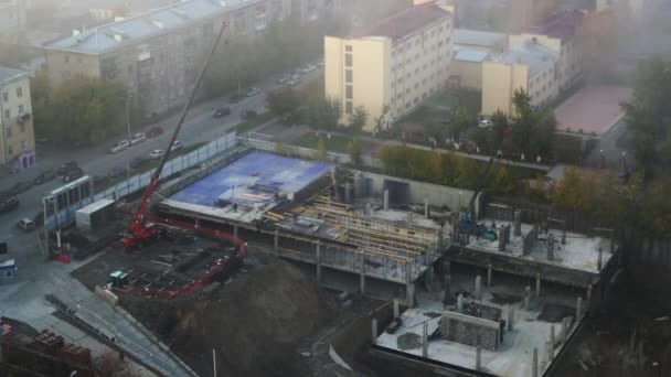 Les ouvriers constructeurs avec une grue construisent un bâtiment. Construction vue aérienne, time-lapse. Russie, Novossibirsk, rue Kirova / Sakko et Vancetti, 2017-10-06 — Video
