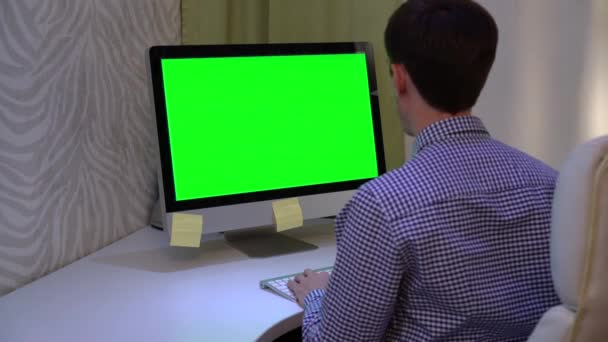 Junger Mann auf seinem Laptop-PC mit grünem Bildschirm. — Stockvideo