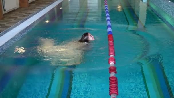 Menina mergulha e nada na piscina — Vídeo de Stock