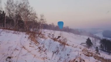 Paraplaner ile bir yayınlanmaya başlar atlar ve akşam ışık karlı Yamaç üzerine çıkartıyor.