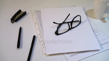 adam gözlüklerini tablosundan alır. Kağıt ve kalem beyaz bir arka plan üzerinde