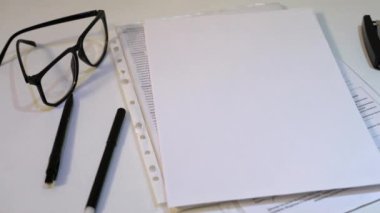 Beyaz Ofis Masası. Kağıt, kalem, Zımba, beyaz bir arka plan üzerinde gözlük