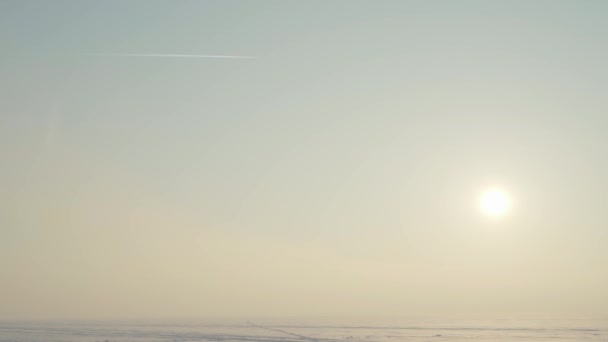 Avião Voa Céu Deixando Uma Trilha Sobre Campo Neve Congelado — Vídeo de Stock