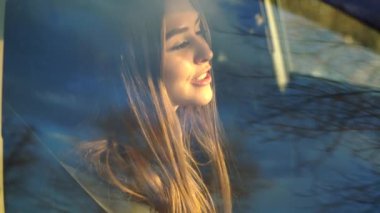 pencereden çekim arabada otururken şarkı söyleyen güzel kız